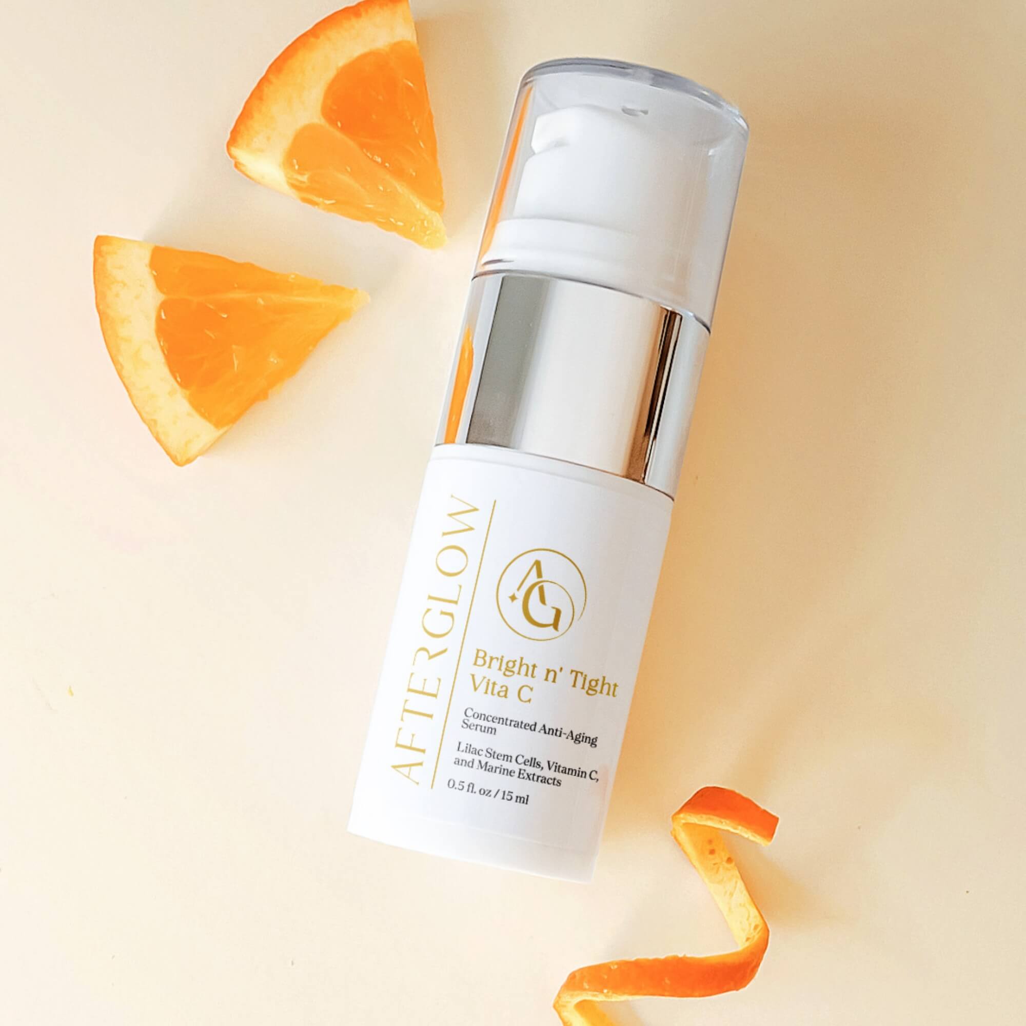 Afterglow Skin Co. Bright n' Tight Vita C travel size serum with orange slices and peel on a light background