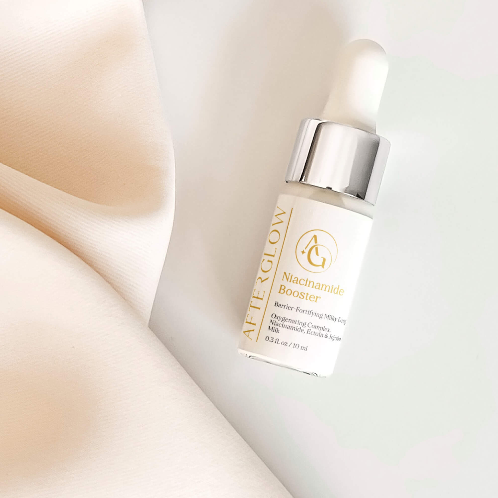 Afterglow Skin Co. Niacinamide Booster serum bottle with dropper on a soft beige background