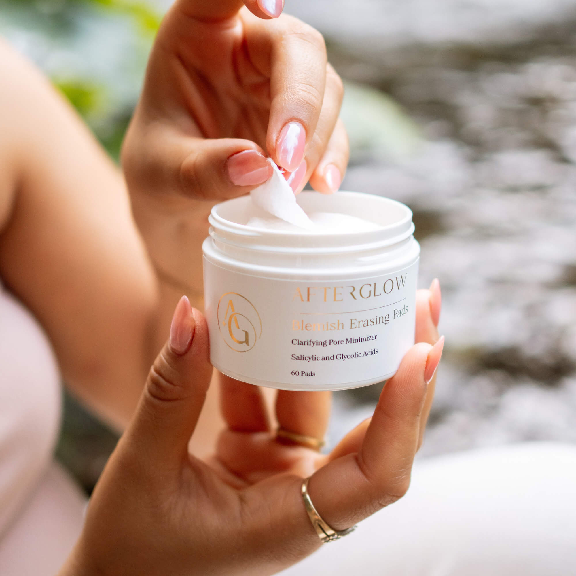 woman holding blemish erasing pads